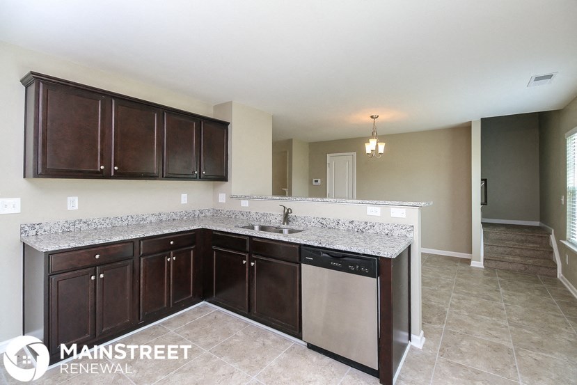 a kitchen with granite counter tops and wooden cabinets