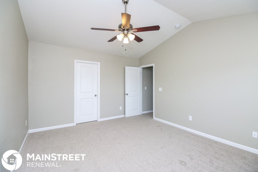 the master bedroom is spacious and has a ceiling fan