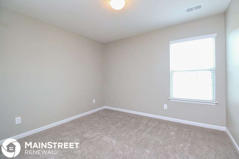 a bedroom with a carpeted floor and a window
