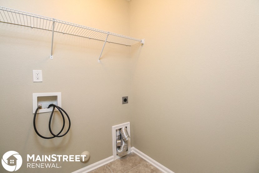 a walk in closet with a wire rack on the wall