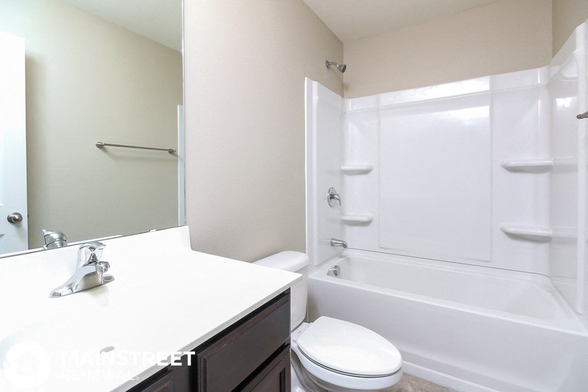 a white bathroom with a tub and a sink and a toilet