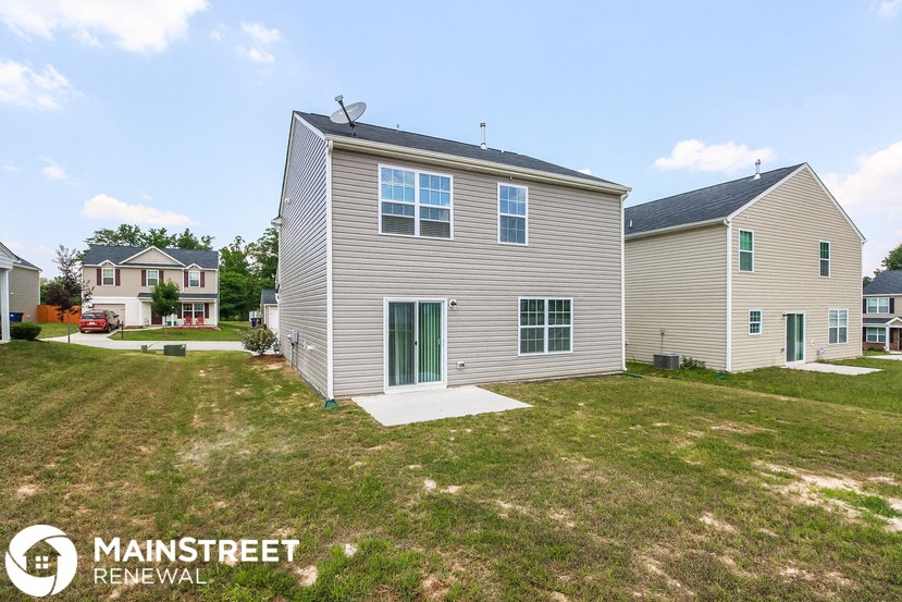 a renovated house with a yard and a green door