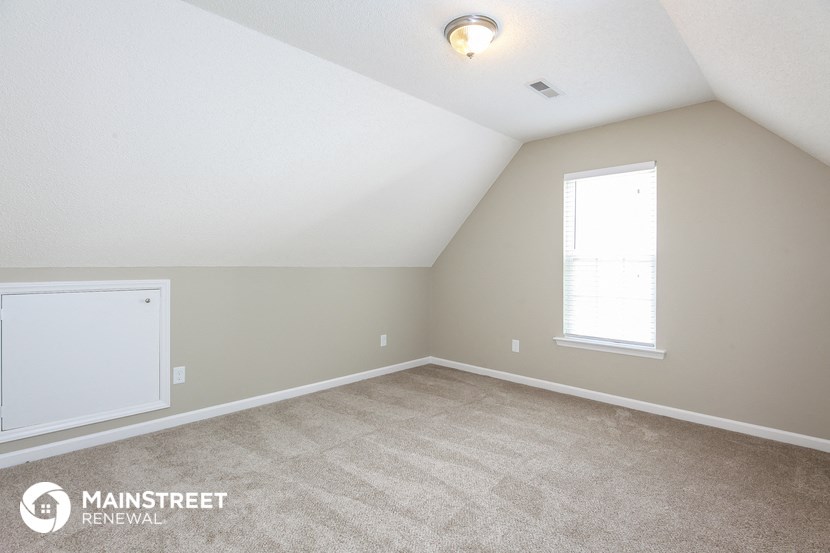 the upstairs bedroom with carpet and a window