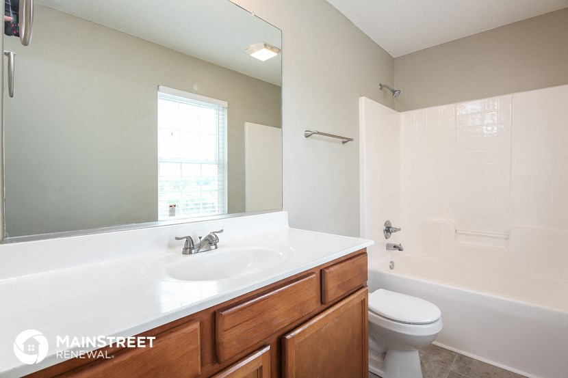 a bathroom with a large mirror and a sink and a toilet