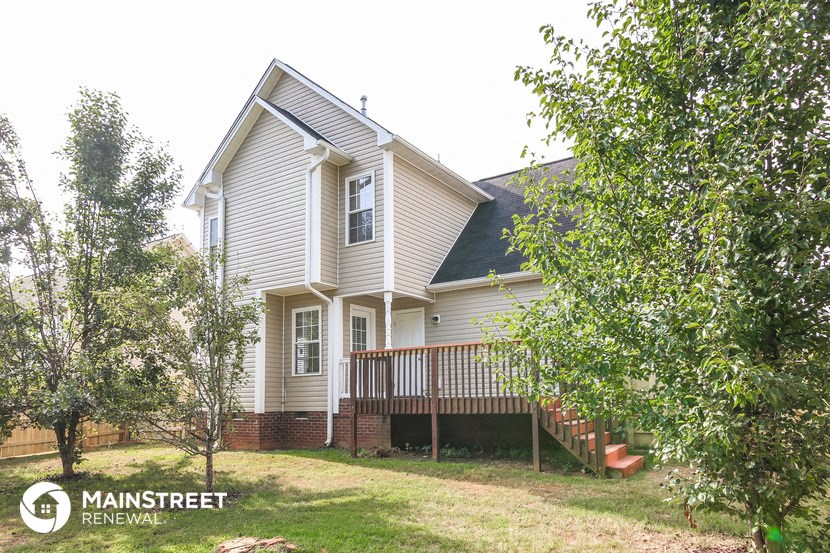 a white house with a porch and a wood deck