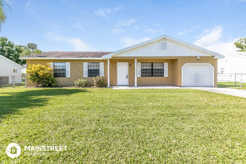 a yellow house with a lawn in front of it