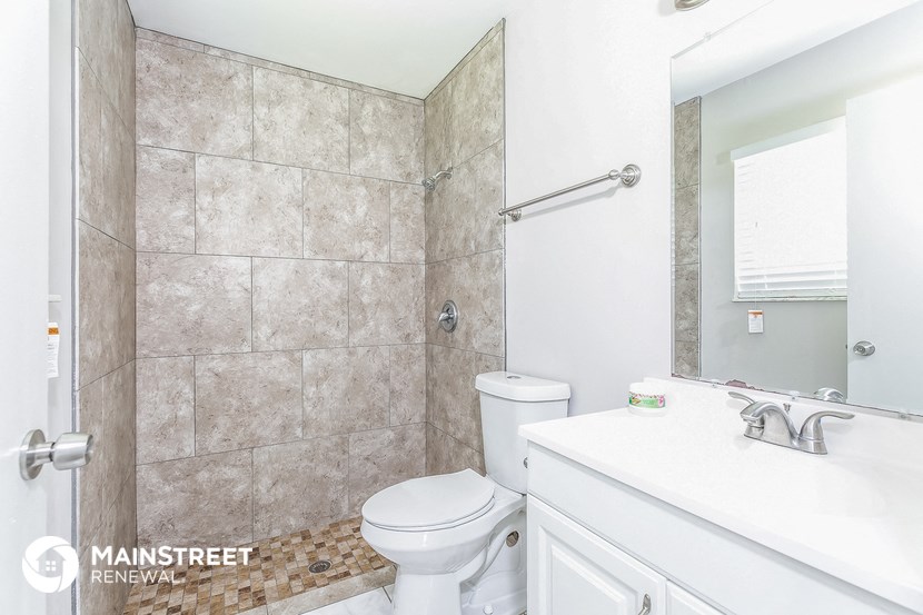 a white bathroom with a shower toilet and sink