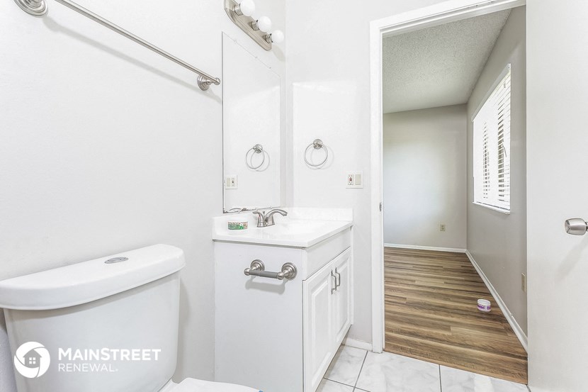 a bathroom with a toilet and a sink and a mirror