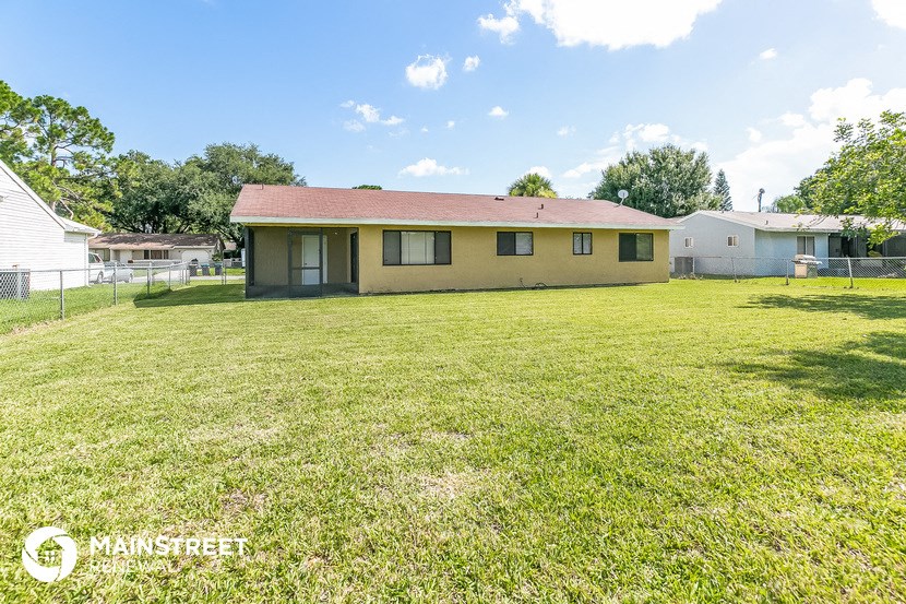 a small yellow house with a large grassy yard