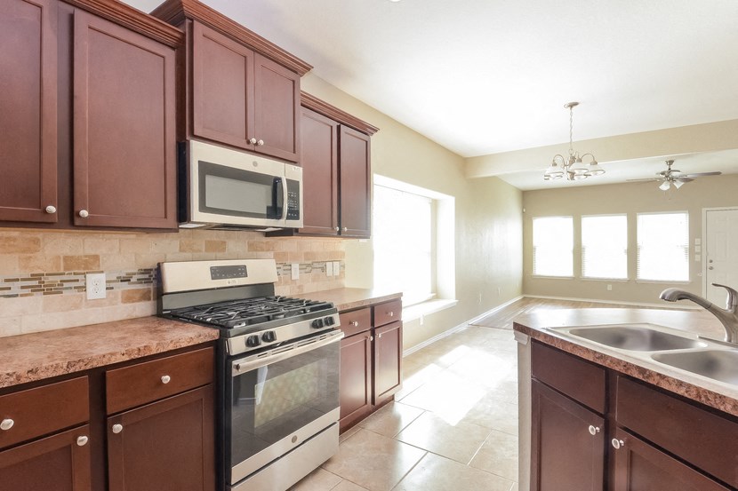 a kitchen with wooden cabinets and stainless steel appliances