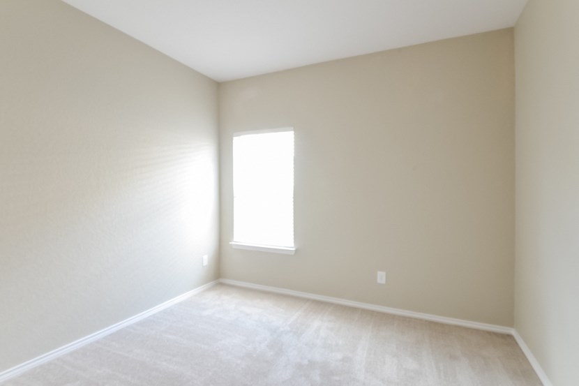 an empty room with white walls and a window