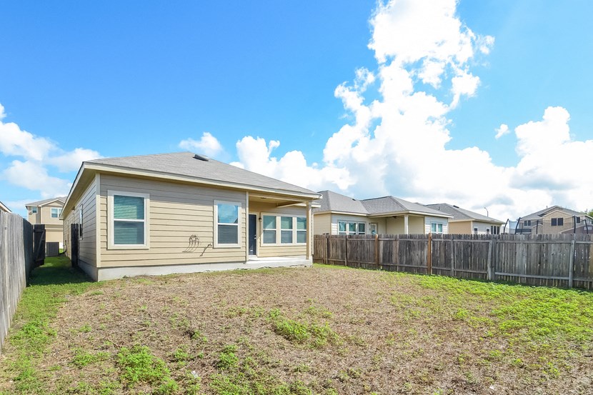 the backyard of a house with a yard and a fence