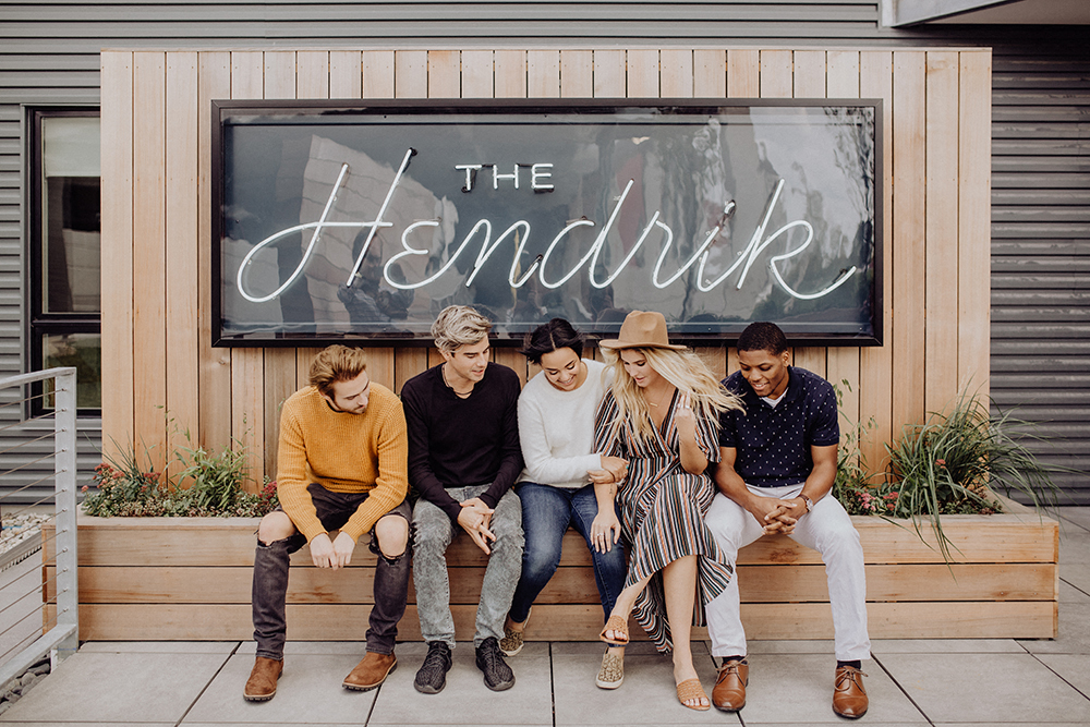 a group of people sitting on a bench in front of a building