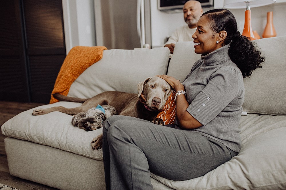 a woman sitting on a couch with a dog on her lap