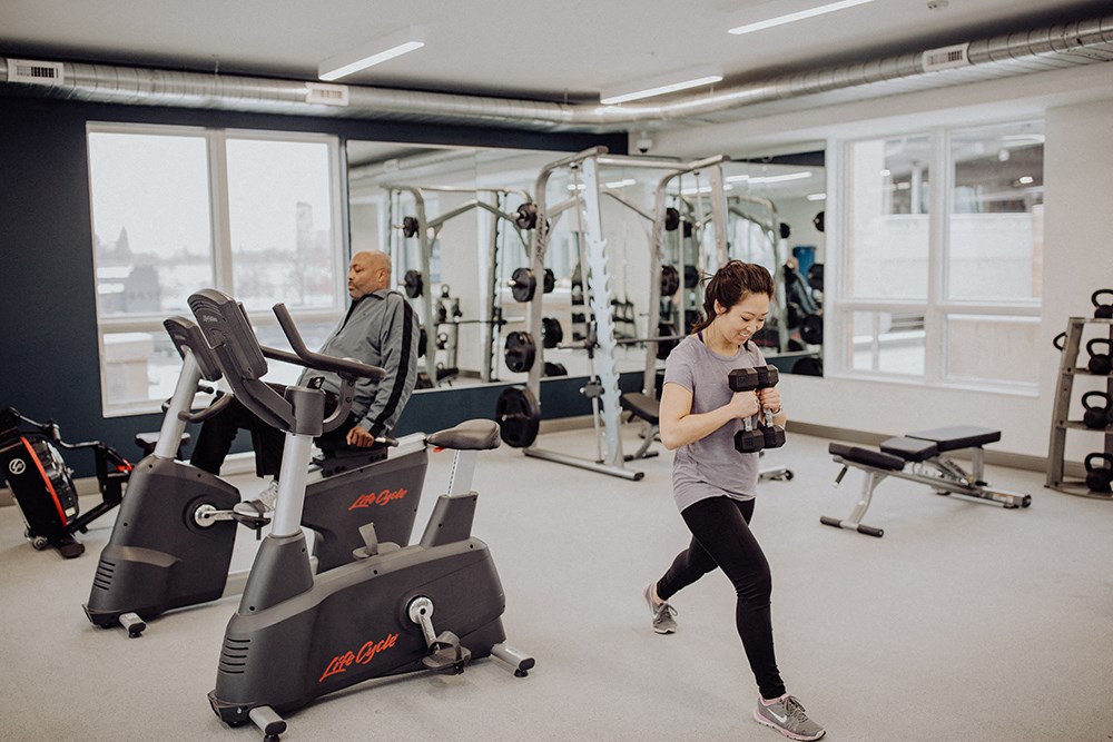 a woman running on a treadmill in a gym with cardio equipment
