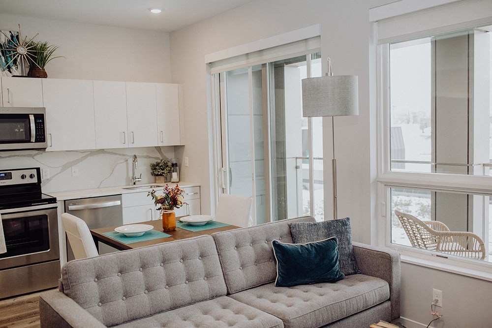 a living room and kitchen with a couch and a table