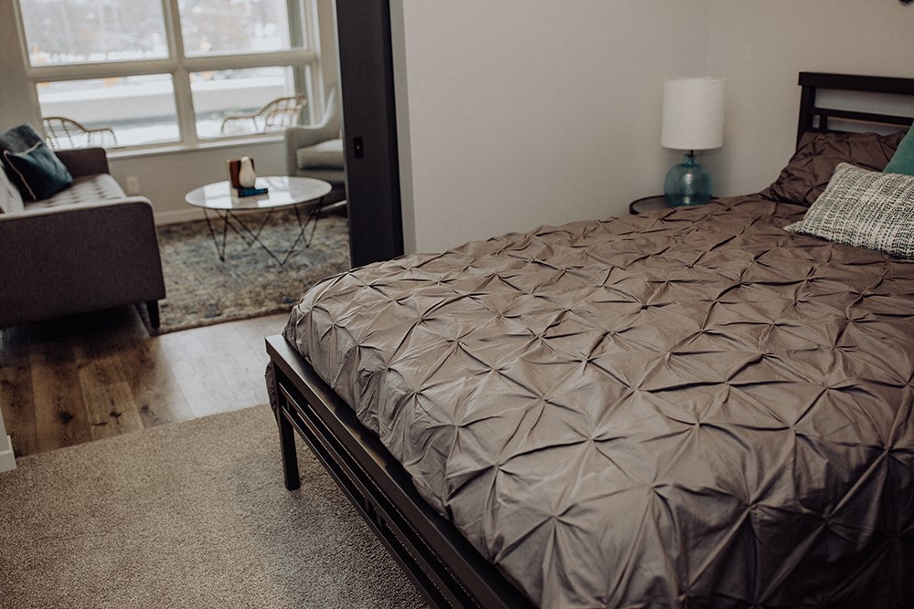 a bedroom with a bed and a chair and a table