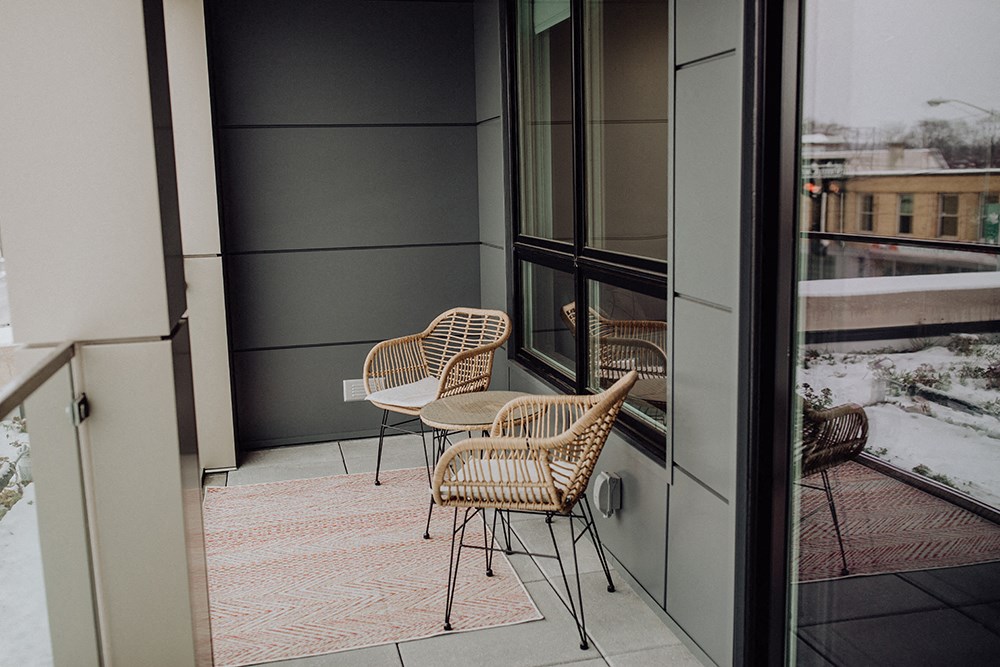a balcony with two chairs and a table and a window