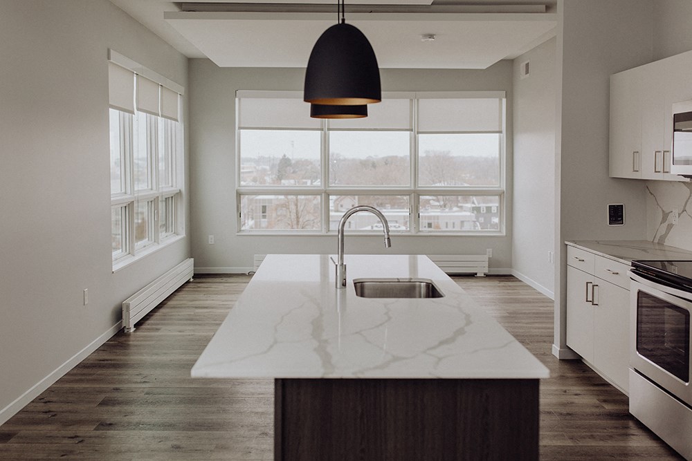 an empty kitchen with a sink and a large window