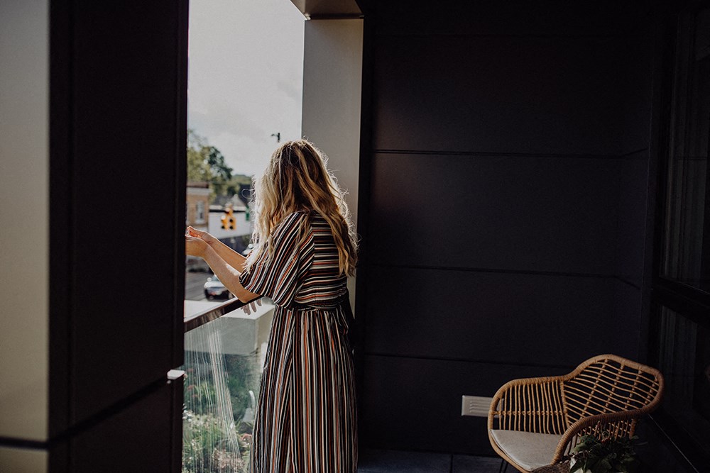 a woman in a striped dress looking out of a window