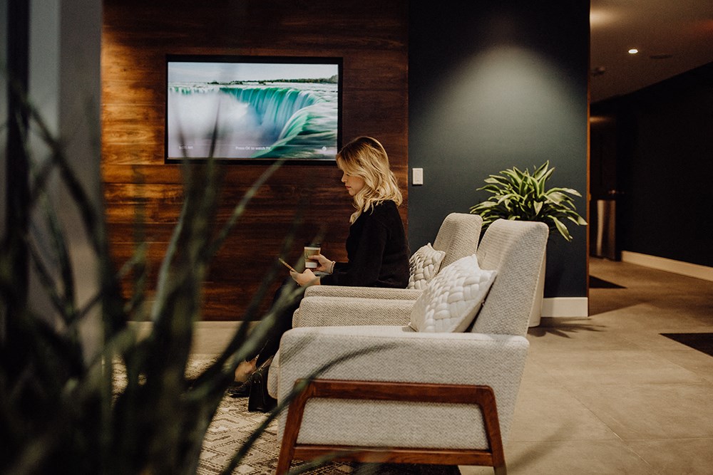 a woman sitting on a couch in a living room watching tv