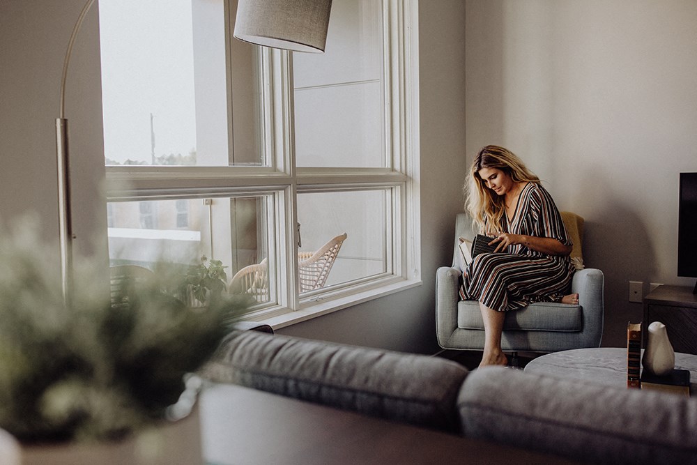 a woman sitting in a chair looking out a window