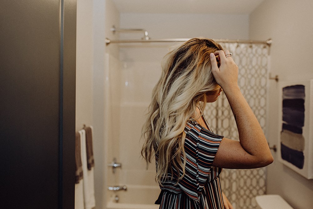 a woman brushing her hair in a bathroom