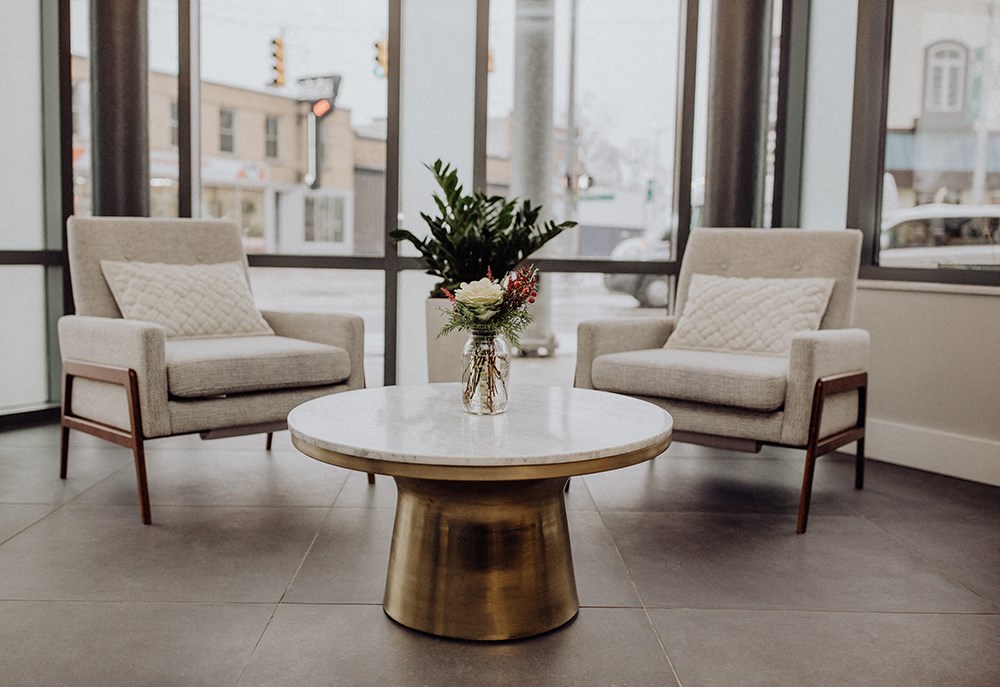 a living room with two chairs and a table with flowers