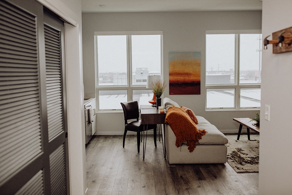 a living room with a table and a couch and a window