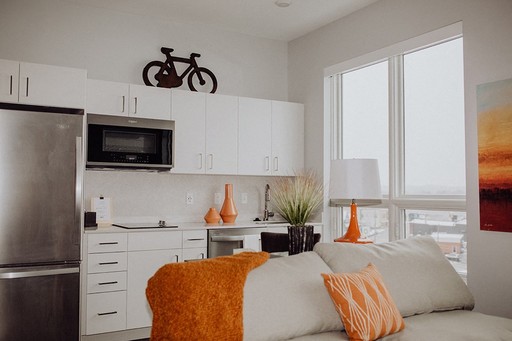 a kitchen with white cabinets and a stainless steel refrigerator