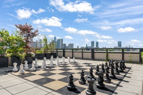 a chess board on a roof with the city in the background