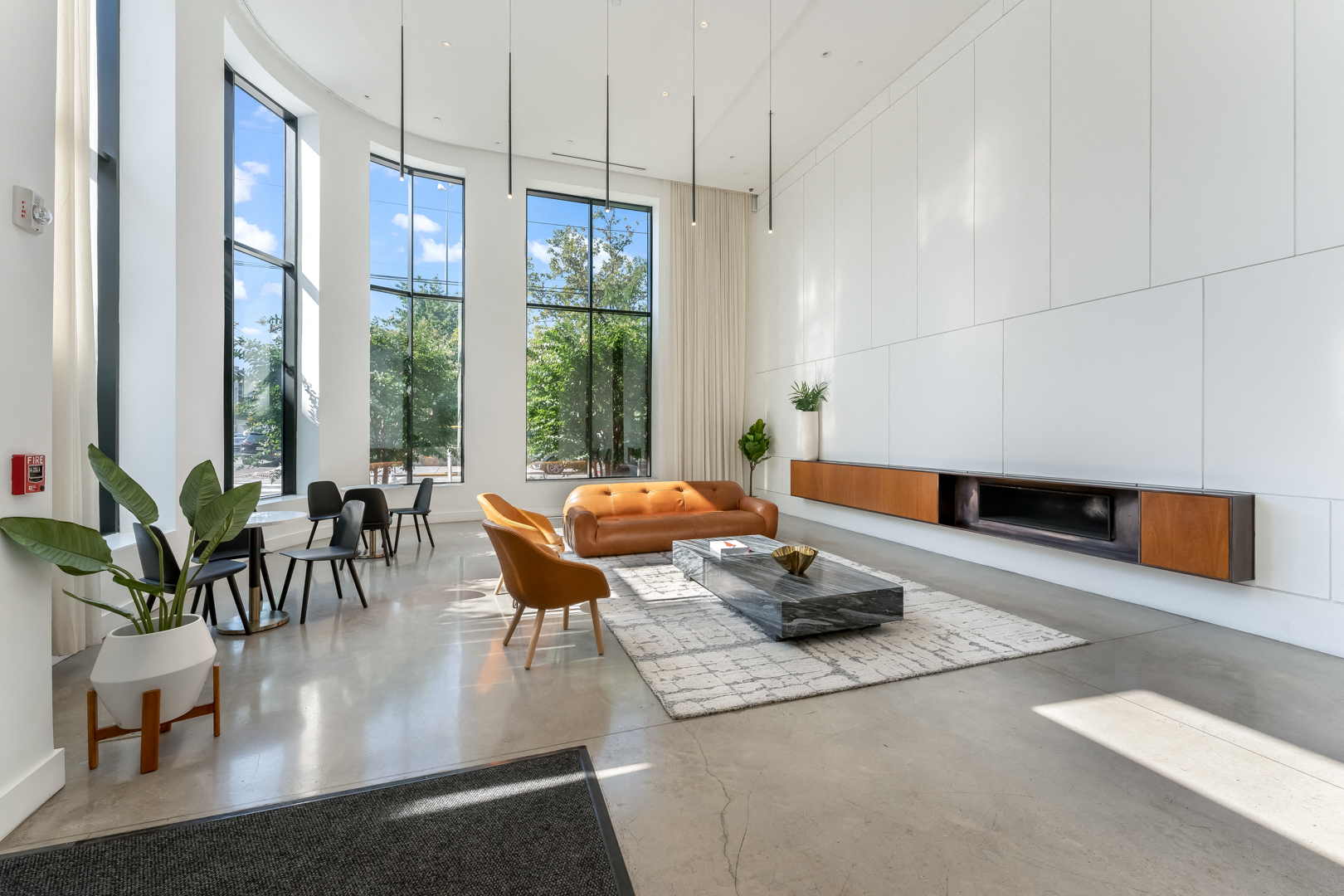 a living room with white walls and a long couch and a table and chairs