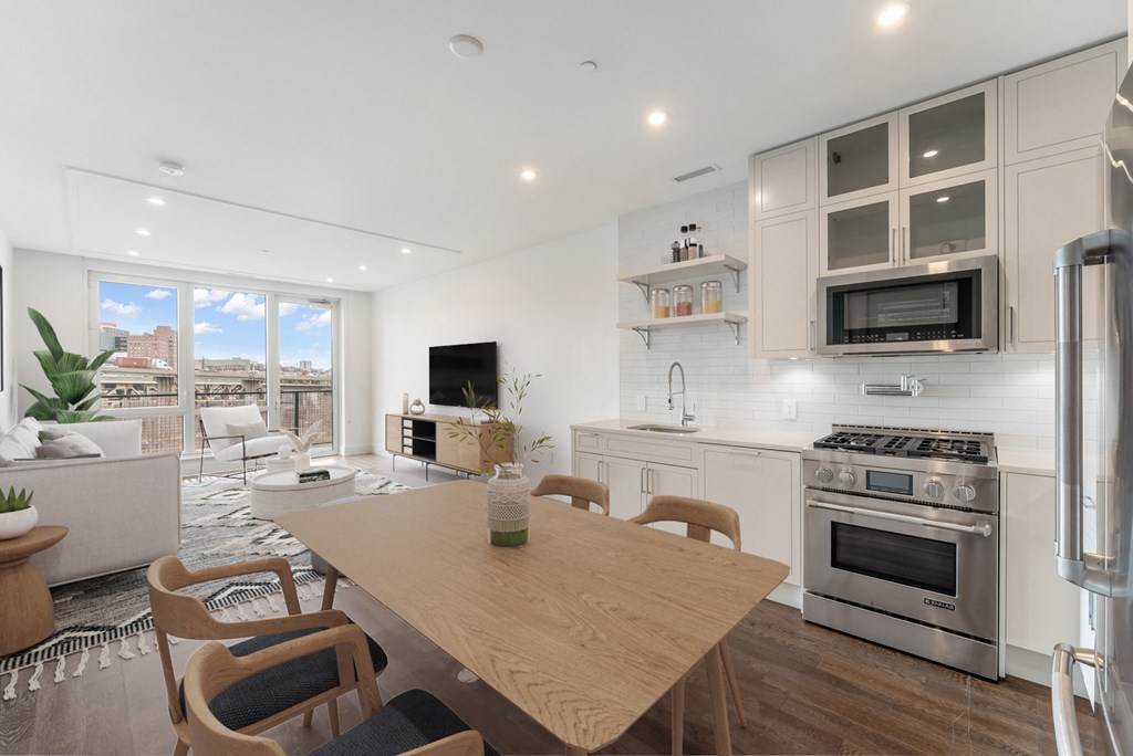 a kitchen and living room with a wooden table