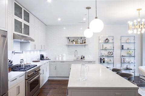 a white kitchen with an island and stainless steel appliances