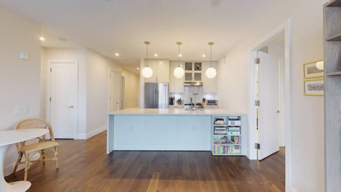 a kitchen with a blue island and a living room