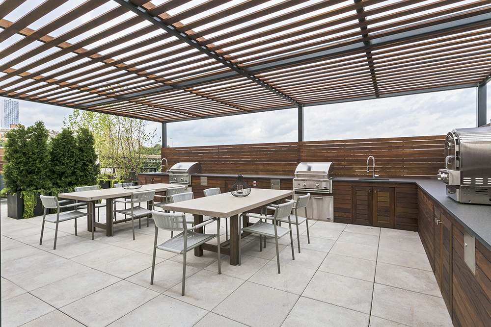 a patio with tables and chairs and a grill