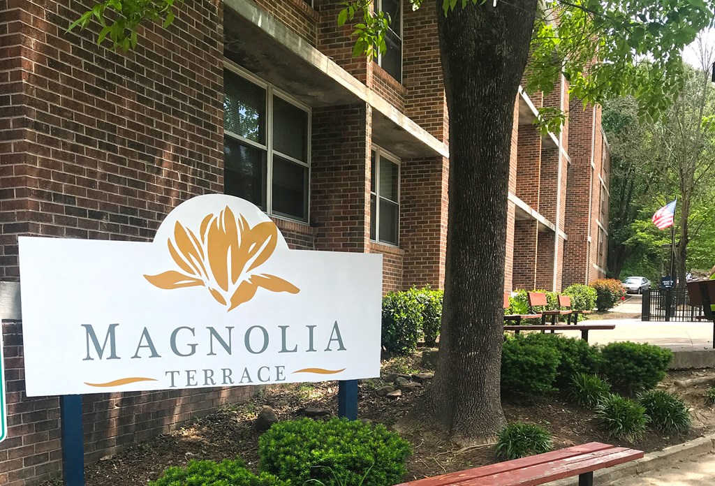 a magnolia terrace sign in front of a brick building