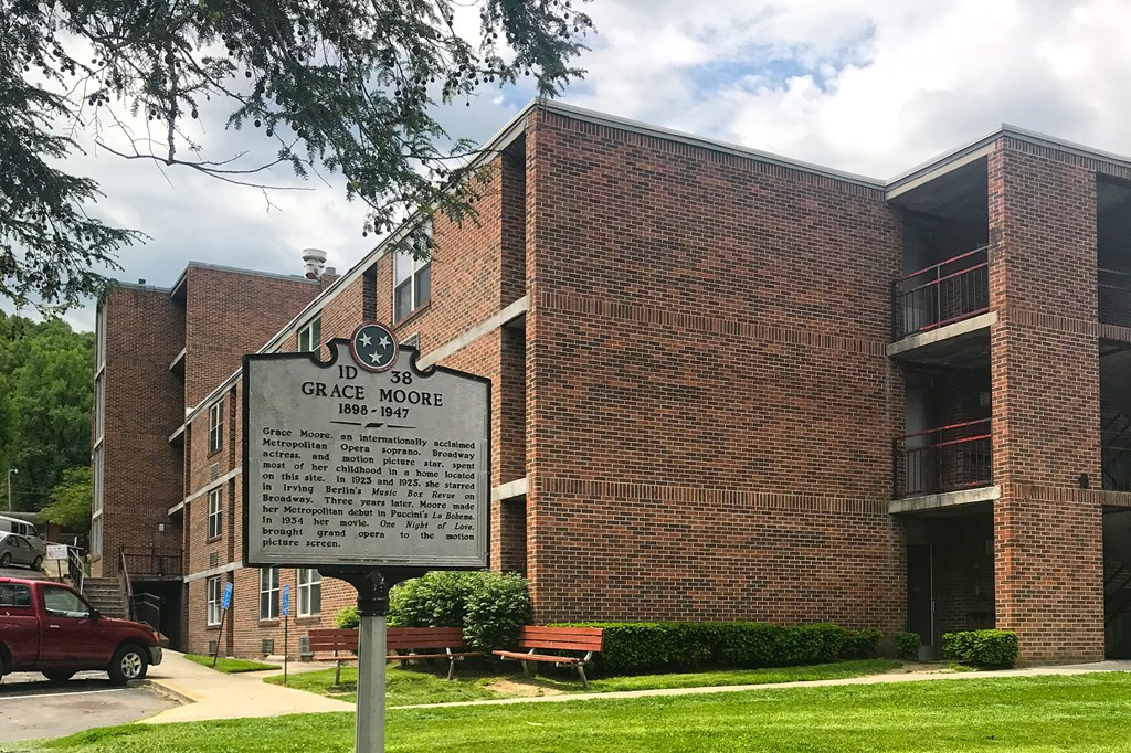 a historical marker in front of a brick building