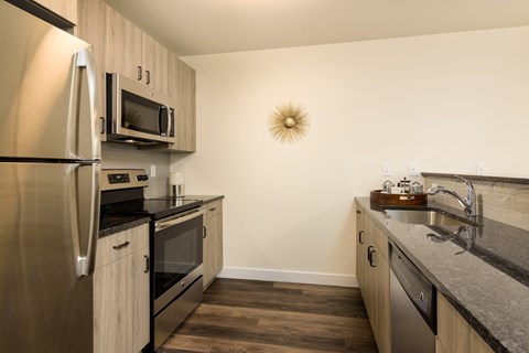a kitchen with stainless steel appliances and granite counter tops and a stainless steel refrigerator