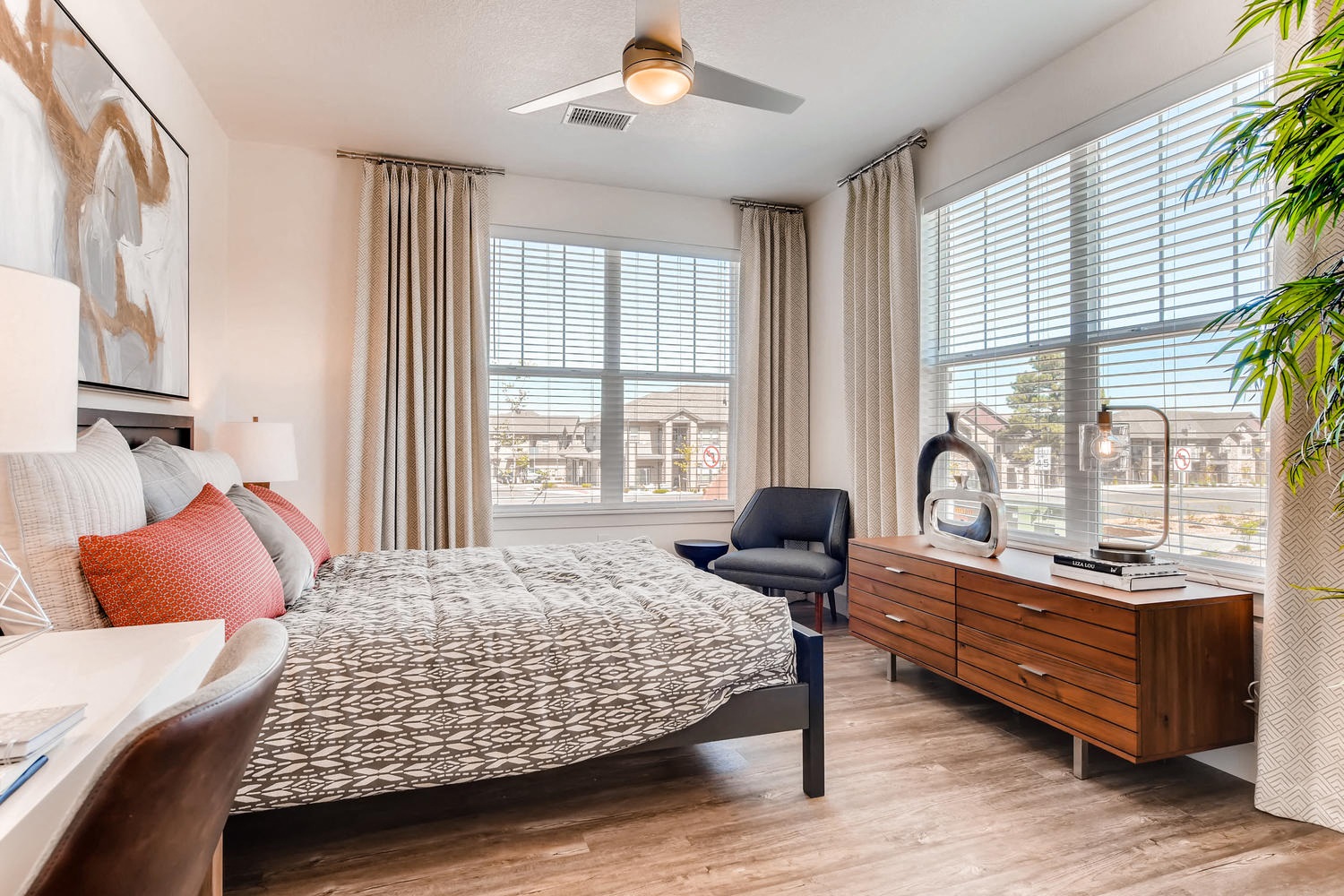 a bedroom with a large window and a bed and a dresser