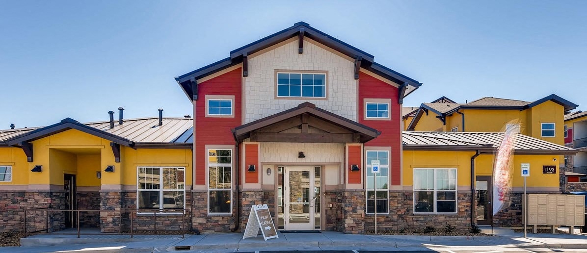 a red and yellow building with a sign in front of it