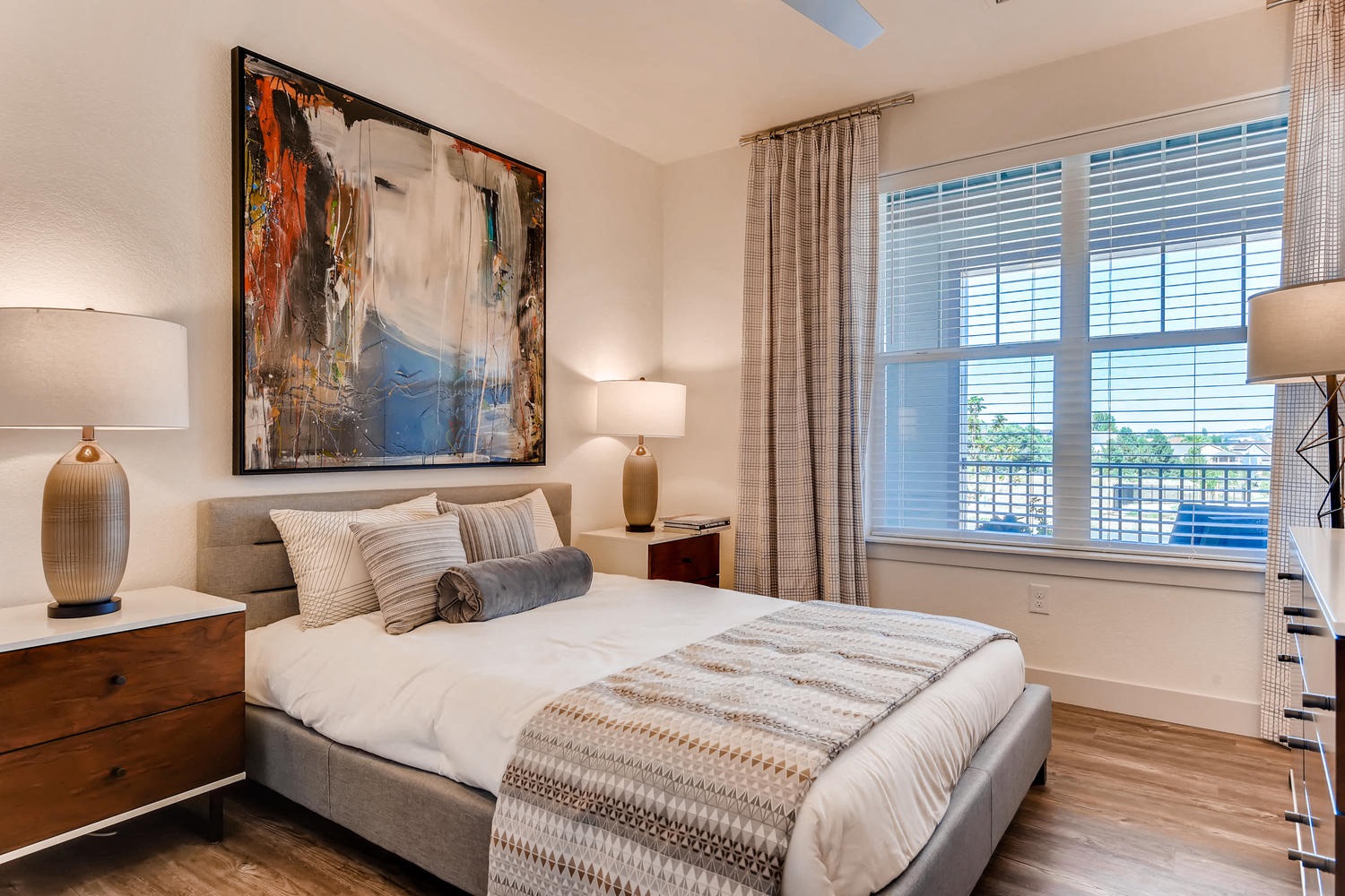 a bedroom with a bed and a large painting on the wall