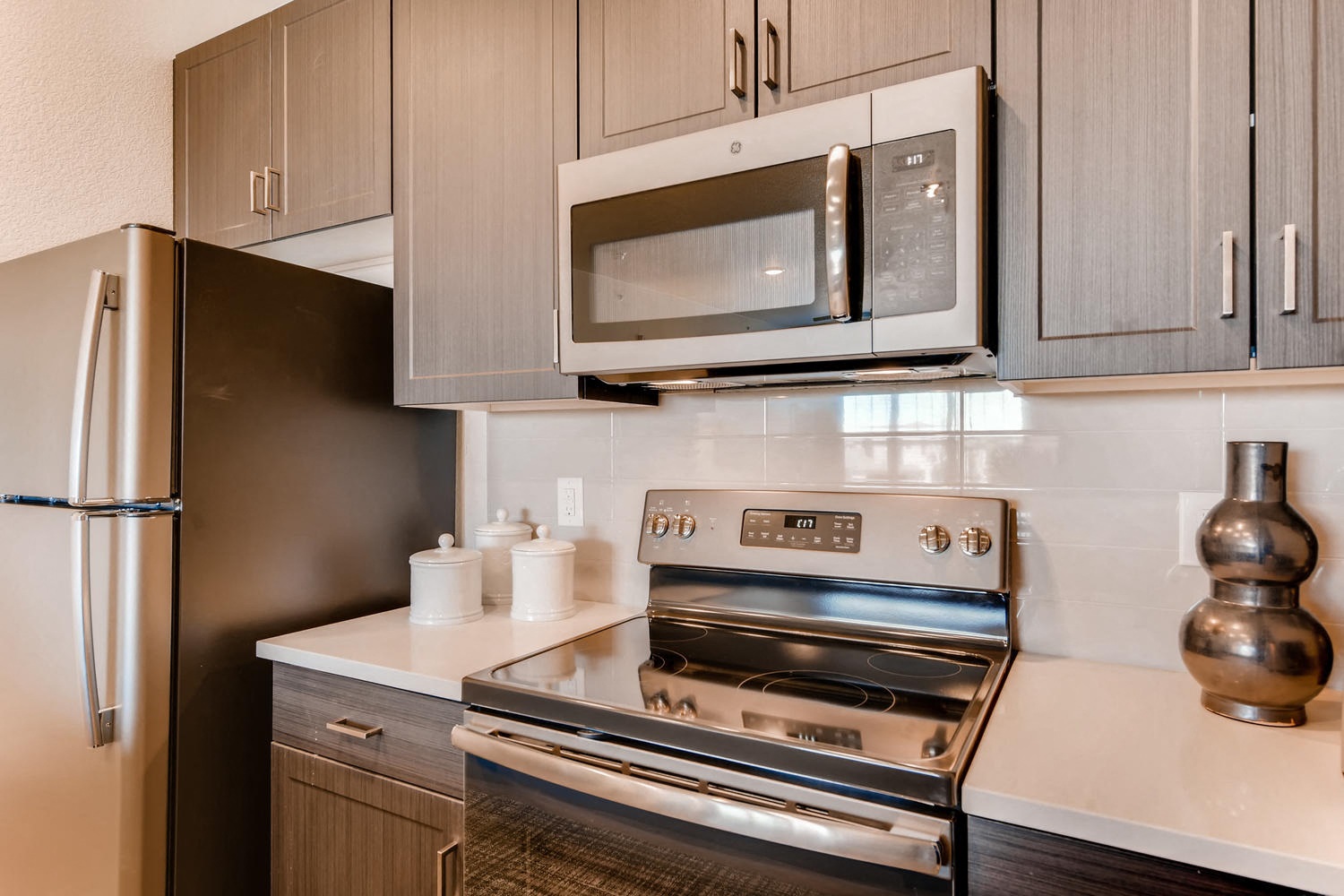 a kitchen with a stove and microwave and a refrigerator