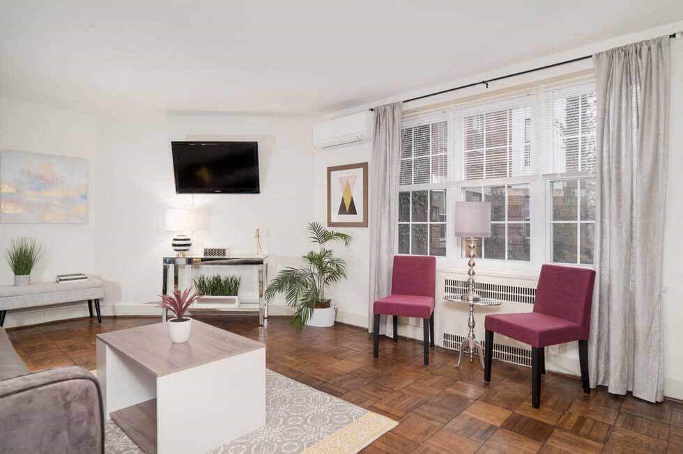 a living room with a couch and chairs and a tv