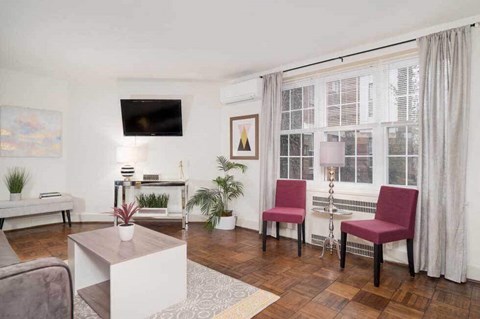 a living room with a couch and chairs and a tv