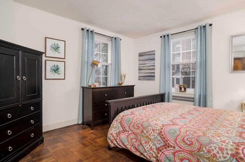 a bedroom with a bed and two windows