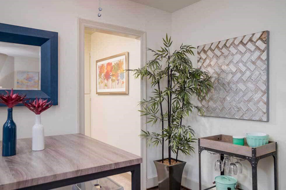 a dining room with a wooden table and a potted plant
