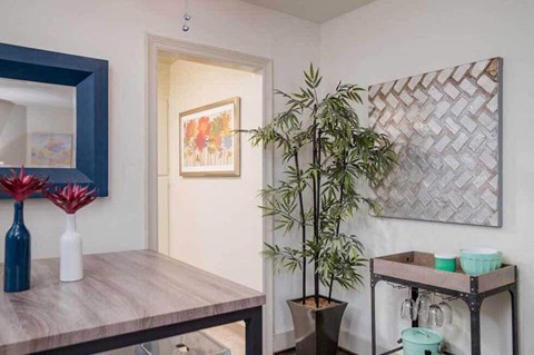 a dining room with a wooden table and a potted plant