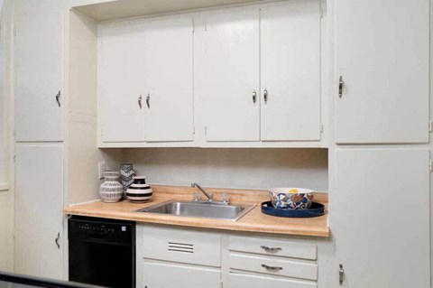 a small kitchen with white cabinets and a sink
