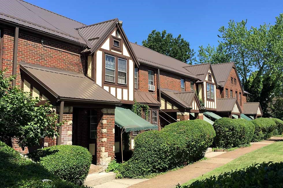 a row of houses on a street with a sidewalk